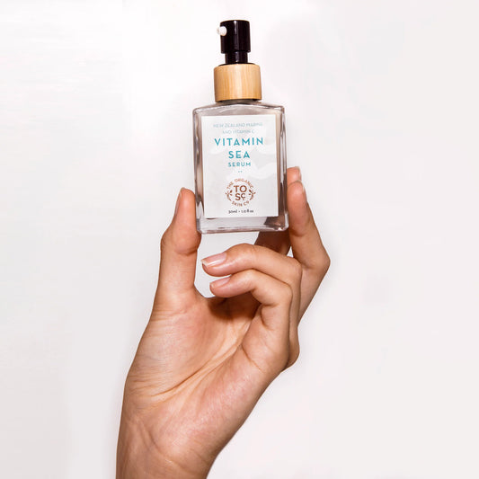 Hand holding a bottle of Vitamin Sea Serum against a white background